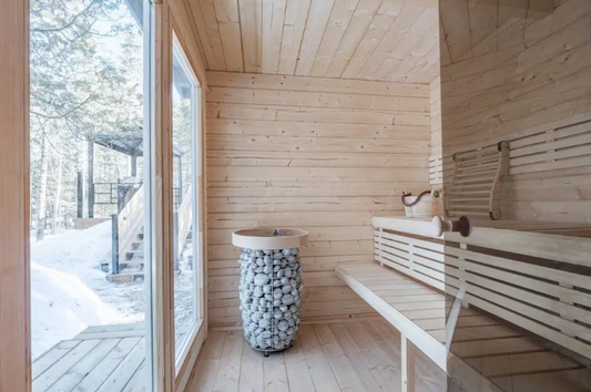 Panca e secchio di pietre in una sala sauna.