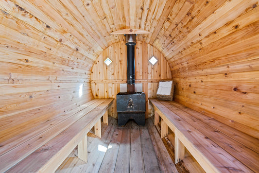 Sala sauna con fornello e panche in legno.