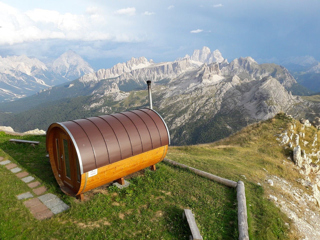 Sauna a barili su una collina con le montagne sullo sfondo.