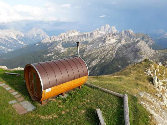 Sauna a barili su una collina con le montagne sullo sfondo.