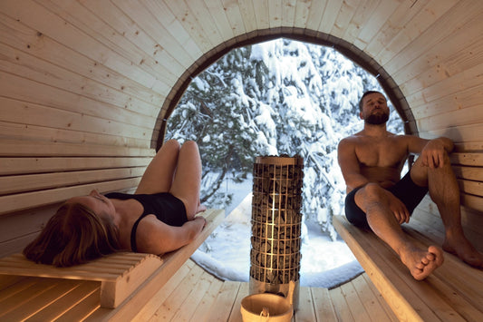 Uomo e donna si rilassano in una sauna all'aperto.