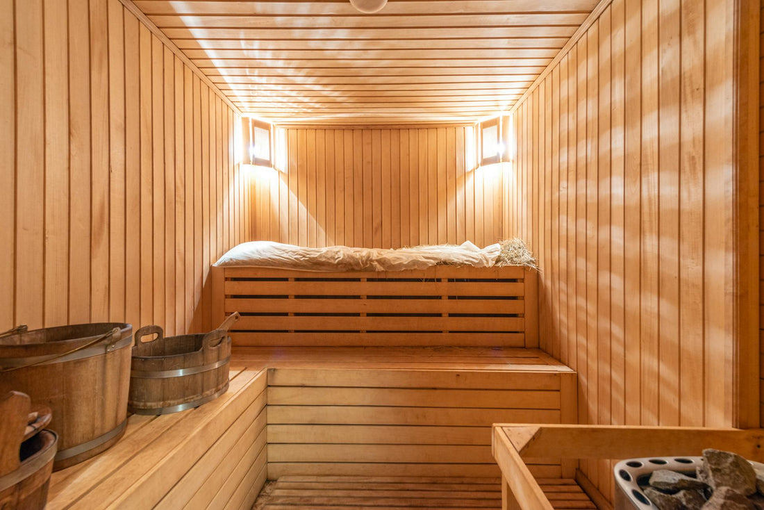 Sauna in legno con panca e secchio.