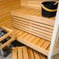 Sauna angolare Sirius con panche in legno e secchio nero.