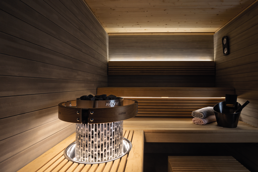 Illuminazione LED Harvia nella sauna con pietre e secchio.