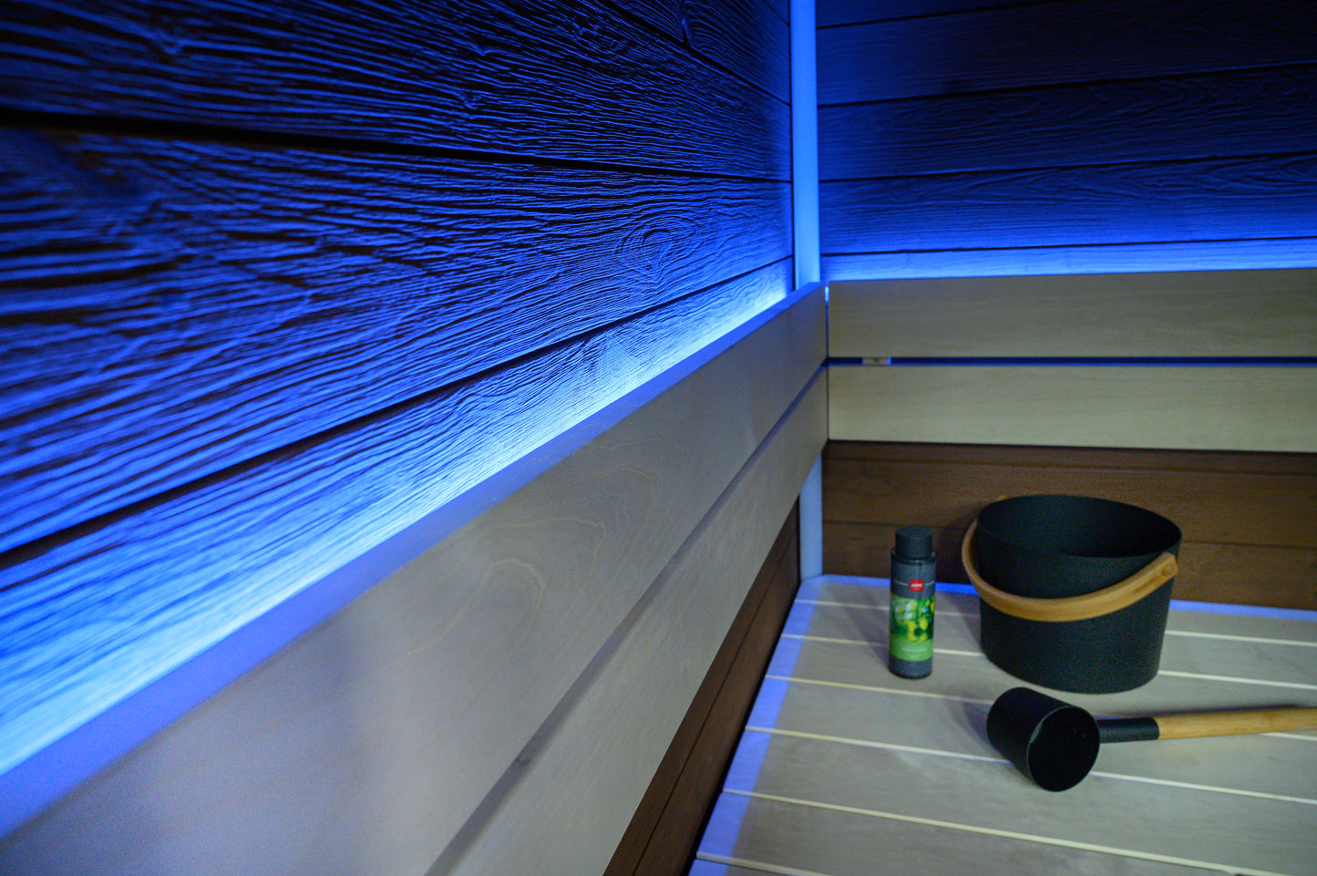 Sauna a blocchi con illuminazione a LED e secchio nero.