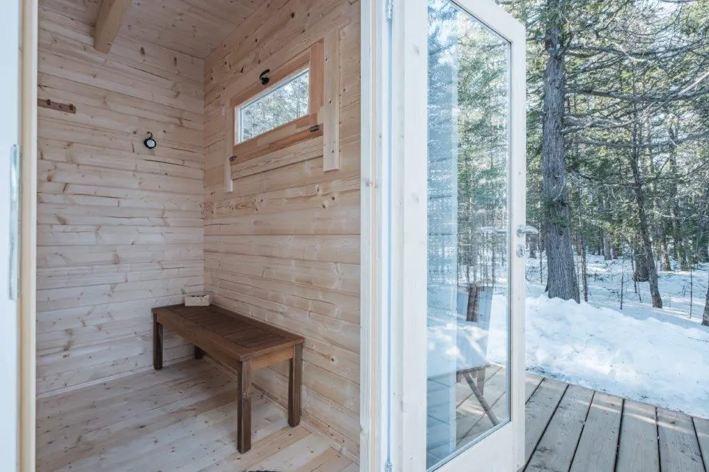 Saunamo Sauna esterna Nordica con porta in vetro e finitura in legno.