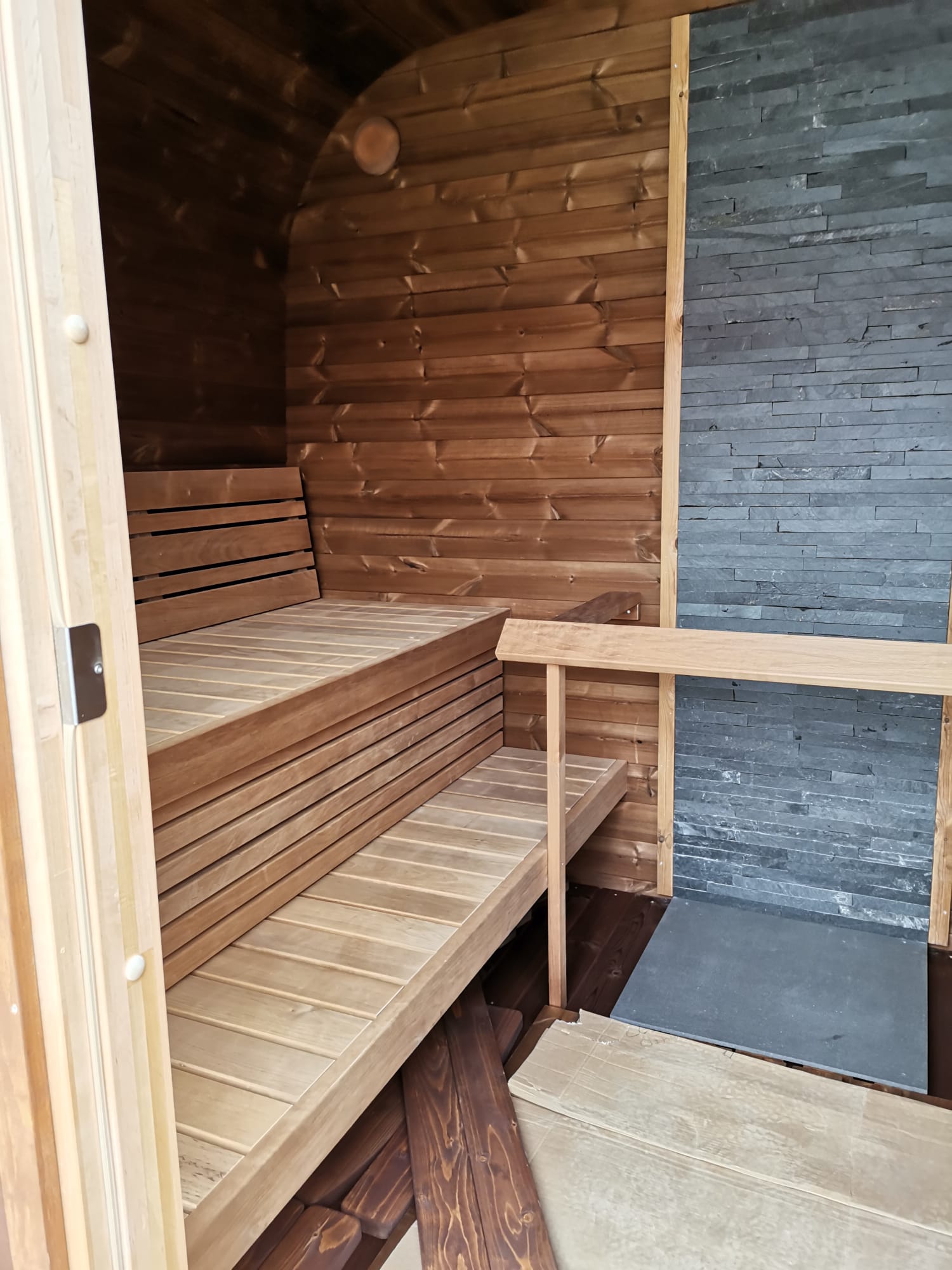 Saunamo Cubo sauna con parete parziale in pietra.