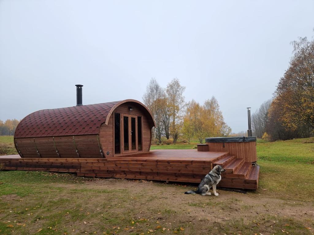 Saunamo Sauna Hobbit 500 accanto al ponte di legno.