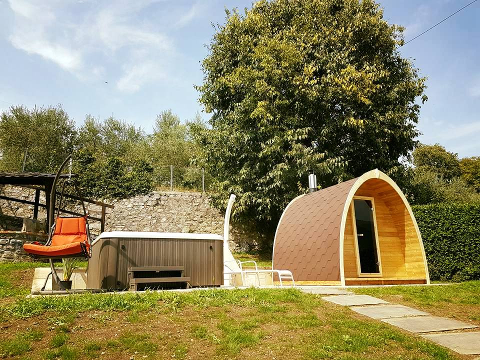 Saunamo Pod accanto a una capanna di legno e a un giardino.